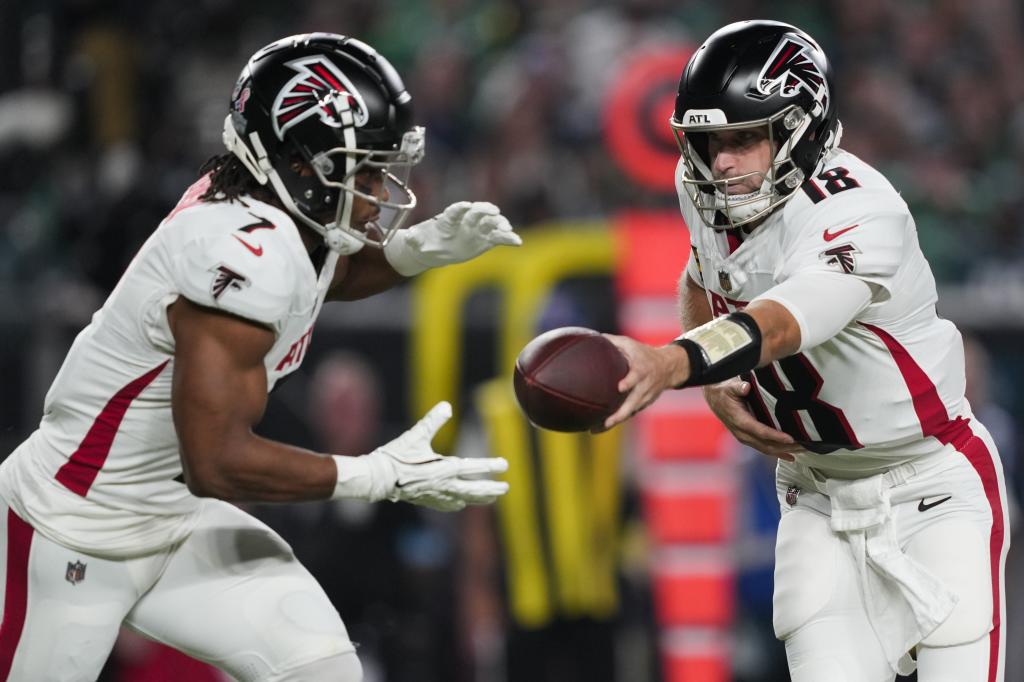 Atlanta Falcons quarterback Kirk Cousins ​​(18) hands off to Falcons running back Bijan Robinson (7) during the first half of an NFL football game against the Philadelphia Eagles on Monday, Sept. 16, 2024, in Philadelphia. (AP Photo/Matt Rourke)