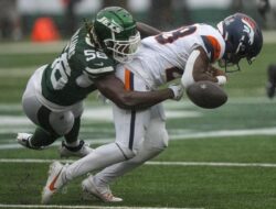 Denver Broncos’ Tyler Badie collapses on the bench after a crash minutes before